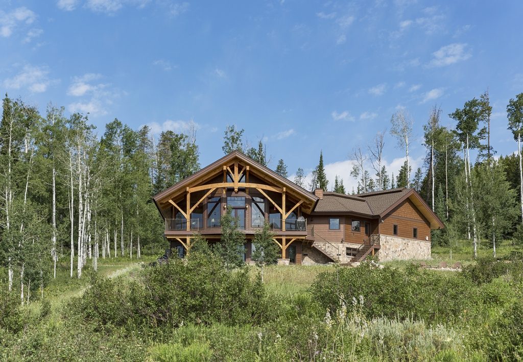Timber-frame home surrounded by aspens in summer